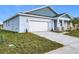 New construction home with light blue exterior and a white garage door at 4902 Pall Mall E St, Kissimmee, FL 34758