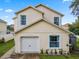 Two-story house with a white garage door and landscaping at 4420 Hamlet Ct, Kissimmee, FL 34746