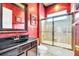 Charming bathroom with red walls, black vanity, and a gold framed mirror at 8168 Via Bella Notte, Orlando, FL 32836