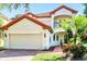 Two-story house with a red tile roof, attached garage, and lush landscaping at 8168 Via Bella Notte, Orlando, FL 32836