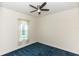 Bright bedroom with a window, ceiling fan, and blue carpet at 18920 Overton St, Orlando, FL 32833