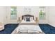 Bright bedroom with a queen-size bed, blue carpet, and two nightstands at 18920 Overton St, Orlando, FL 32833