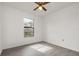 Bedroom features gray floors, white ceilings and walls, a ceiling fan, and a window at 3186 Mapleshade St, Deltona, FL 32738