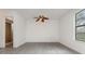 This bedroom features a ceiling fan, light gray floors, and an adjacent bathroom at 3186 Mapleshade St, Deltona, FL 32738