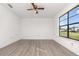 Bright bedroom with new flooring, neutral paint, and a large window offering a view at 3186 Mapleshade St, Deltona, FL 32738