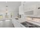 Bright open kitchen with white cabinets, quartz countertops, and stainless steel appliances at 3186 Mapleshade St, Deltona, FL 32738