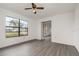 Bright living room features a ceiling fan and large window letting in natural light at 3186 Mapleshade St, Deltona, FL 32738