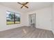 Bright living room boasts updated floors, a ceiling fan, and a large window offering neighborhood views at 3186 Mapleshade St, Deltona, FL 32738