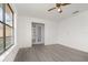 The living room boasts gray plank flooring, and a window for lots of natural light at 3186 Mapleshade St, Deltona, FL 32738