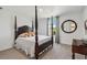 Bedroom with a four poster bed, carpet floors, and a round mirror at 720 Split Hoof Dr, Saint Cloud, FL 34771