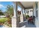 Covered porch with stone pillars and wicker chair, inviting entryway at 720 Split Hoof Dr, Saint Cloud, FL 34771