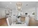 Open-concept dining area with modern lighting, adjacent to a bright kitchen and cozy living room at 13163 Mcmillan Dr, Orlando, FL 32827