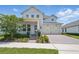 Charming two-story home with a brick driveway, manicured landscaping, and attached two-car garage at 13163 Mcmillan Dr, Orlando, FL 32827