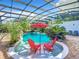 Relaxing screened pool with two red chairs at 226 Mitnik Dr, Deltona, FL 32738