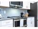 Close-up of kitchen with stainless steel appliances and modern white and gray design at 2709 Scrapbook St, Kissimmee, FL 34746