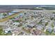 Overhead view of a well-kept residential area with a lake and highway in the background at 1103 Epson Oaks Way, Orlando, FL 32837