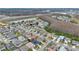 The aerial view showcases a residential area near a highway, featuring well-maintained homes, trees, and a pond at 1103 Epson Oaks Way, Orlando, FL 32837