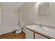A clean bathroom with a tub and shower, toilet, and vanity with a sink, complete with wooden floors at 1103 Epson Oaks Way, Orlando, FL 32837