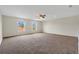 Expansive carpeted bedroom featuring a ceiling fan and multiple windows at 1103 Epson Oaks Way, Orlando, FL 32837