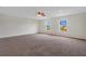 Spacious bedroom with plush carpeting, a ceiling fan, and two windows offering natural light at 1103 Epson Oaks Way, Orlando, FL 32837