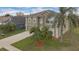 Inviting two-story home with a neutral color, complemented by lush palm trees and a long driveway at 1103 Epson Oaks Way, Orlando, FL 32837