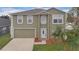 Two-story home featuring an attached garage, a well-kept lawn, and a freshly painted exterior at 1103 Epson Oaks Way, Orlando, FL 32837