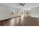 Open-concept living space with wood-look floors, ceiling fan, and sliding glass door to the backyard at 1103 Epson Oaks Way, Orlando, FL 32837