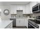 Modern kitchen with white cabinets, mosaic backsplash, and stainless steel appliances at 2142 Hainlin Ct, Deltona, FL 32738