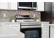 Kitchen showcases stainless steel stove, oven, and range hood against a gray and white backsplash at 2142 Hainlin Ct, Deltona, FL 32738