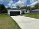 Charming single-story home with a black garage door, white stucco and well-manicured lawn at 442 Marion Oaks Crse, Ocala, FL 34473