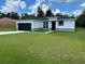 Charming single-story home with a black garage door, white stucco and well-manicured lawn at 442 Marion Oaks Crse, Ocala, FL 34473