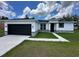 Charming single-story home with a black garage door, white stucco and well-manicured lawn at 442 Marion Oaks Crse, Ocala, FL 34473