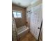 Bright bathroom featuring a white bathtub with tile surround and a window at 10161 Culpepper Ct, Orlando, FL 32836