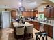 Well-lit kitchen featuring wood cabinets, granite countertops, stainless steel appliances, and a central island with bar seating at 10161 Culpepper Ct, Orlando, FL 32836