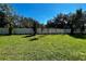 Expansive backyard enclosed by a white fence features lush grass and manicured landscaping, ensuring privacy and tranquility at 329 Lady Palm St, Apopka, FL 32703