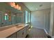 Modern bathroom with double vanity, large mirror, and glass shower enclosure, with neutral color palette at 329 Lady Palm St, Apopka, FL 32703