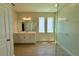 Well-lit bathroom featuring dual sinks, sleek vanity, and a modern glass-enclosed shower at 329 Lady Palm St, Apopka, FL 32703