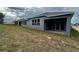 Rear view of a grey house with covered patio and partial landscaping at 329 Lady Palm St, Apopka, FL 32703