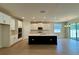 Open-concept kitchen with island featuring sink, double ovens, and bright white cabinets at 329 Lady Palm St, Apopka, FL 32703