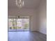 Spacious living room with hardwood floors, balcony access, and chandelier at 5058 Maxon S Ter # 108, Sanford, FL 32771