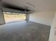 Spacious two-car garage featuring a concrete floor, white brick walls, and an automatic door opener at 791 Pilea St, Apopka, FL 32703