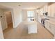 Spacious kitchen with white cabinetry, stainless steel appliances, and a central island flowing into the living spaces at 791 Pilea St, Apopka, FL 32703