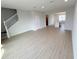 Open-concept living room with wood-look tile flooring leading to the kitchen and a staircase to the second floor at 791 Pilea St, Apopka, FL 32703