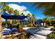 Inviting poolside seating area with comfortable lounge furniture and lush tropical landscaping and blue umbrellas at 2621 Calistoga Ave, Kissimmee, FL 34741