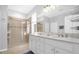 Bathroom with double vanity, large mirror, and walk-in shower at 8162 Lazy Bear Ln, Winter Park, FL 32792