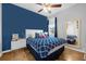 Bedroom with blue walls, hardwood floors, and a queen-size bed at 8162 Lazy Bear Ln, Winter Park, FL 32792