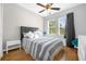 Bedroom with hardwood floors, a striped comforter, and gray headboard at 8162 Lazy Bear Ln, Winter Park, FL 32792