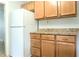 Practical kitchen with light wood cabinetry and ample counter space, complemented by a modern white refrigerator at 1017 Mabbette St, Kissimmee, FL 34741