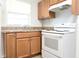 Well-lit kitchen featuring light wood cabinetry, a double basin sink and a modern white stove at 1017 Mabbette St, Kissimmee, FL 34741