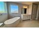 Bathroom features a soaking tub under a large window and single vanity at 3295 Roseville Dr, Apopka, FL 32712